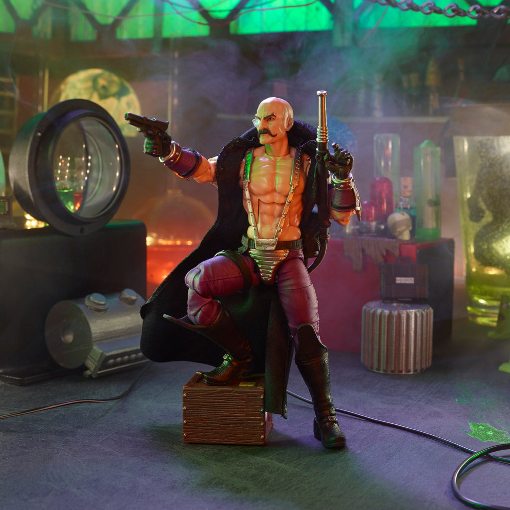 G.I. Joe Classified Series Dr. Mindbender kneeling on crate in M.A.R.S. lab diorama holding pistol and staff with green atmospheric lighting