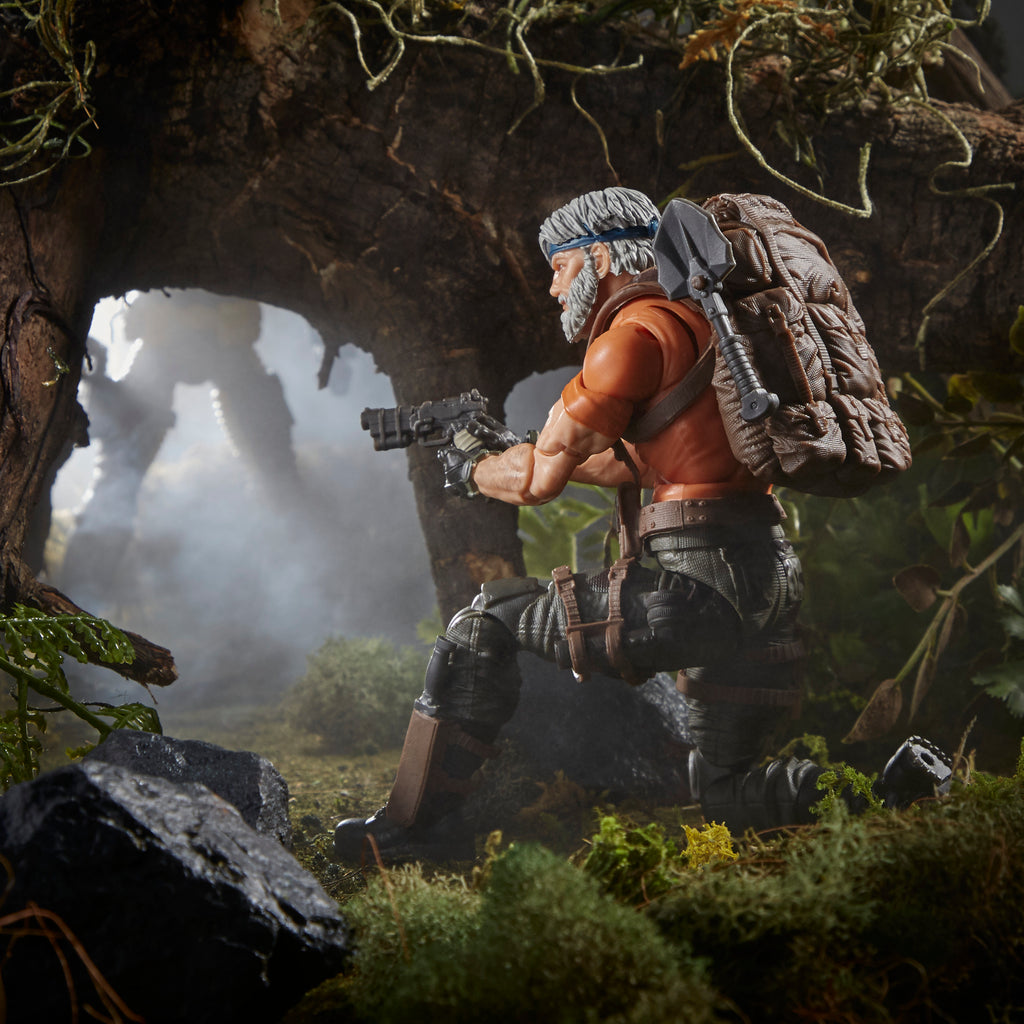 G.I. Joe Classified Series Outback Selkirk close-up aiming assault rifle through jungle foliage in rain