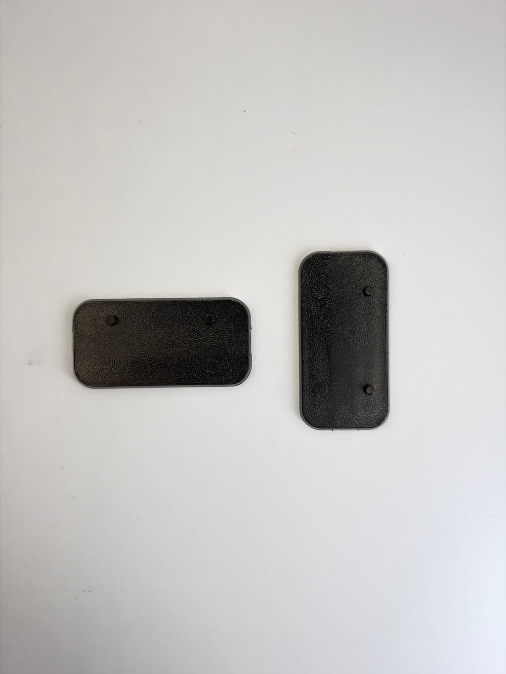 Two black rectangular plastic Action Figure Stands with two foot pegs each, shown on a plain light background.
