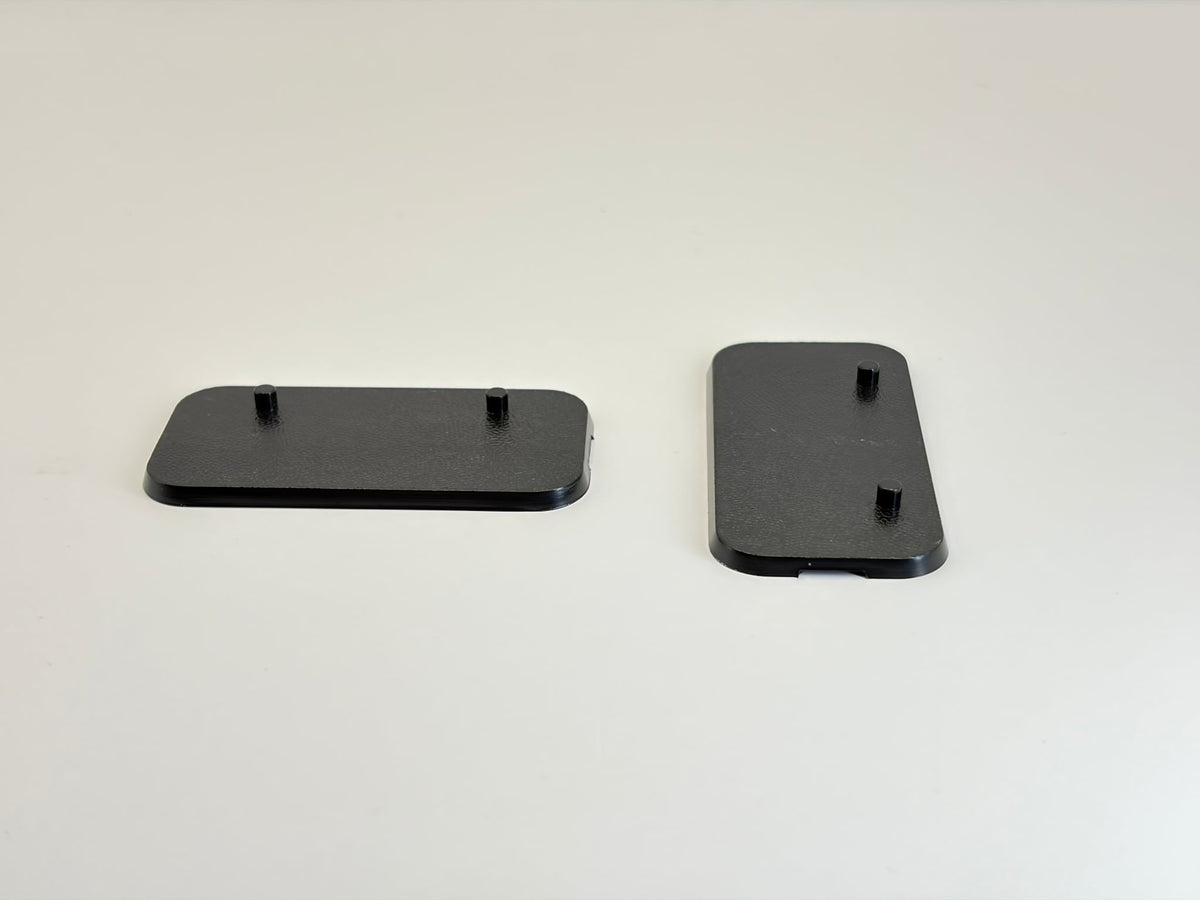 Two black rectangular plastic Action Figure Stands with two foot pegs each, shown on a plain light background.