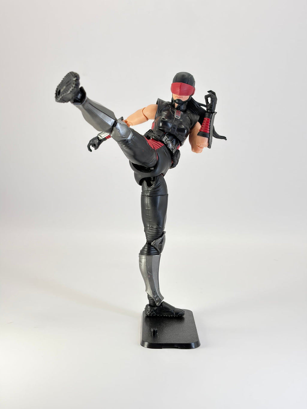 G.I. Joe Classified figure in a dynamic high kick pose, mounted on a black display stand. Figure not included.